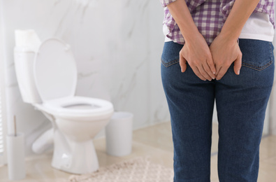 Photo of Woman suffering from hemorrhoid in rest room, closeup