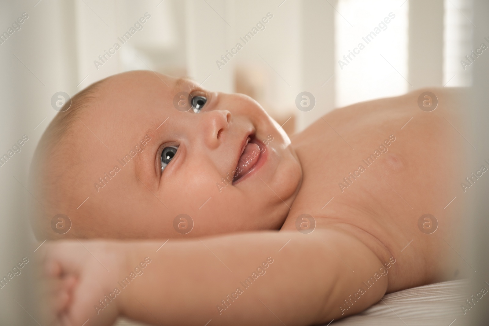 Photo of Cute little baby lying in soft crib