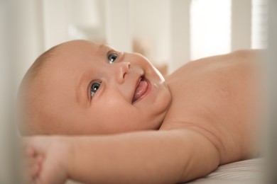 Photo of Cute little baby lying in soft crib