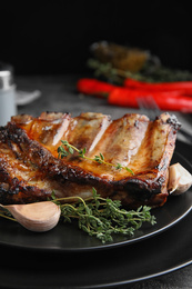 Photo of Tasty grilled ribs with thyme on table