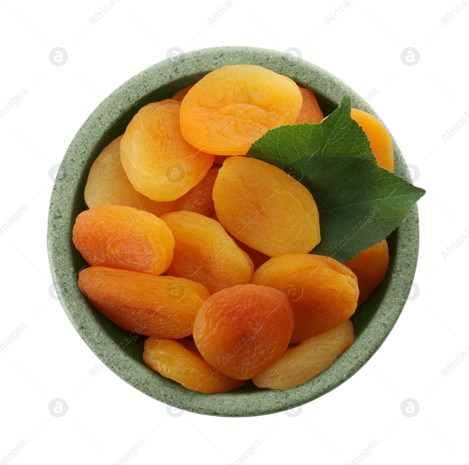 Photo of Ceramic bowl with tasty dried apricots and leaves isolated on white, top view