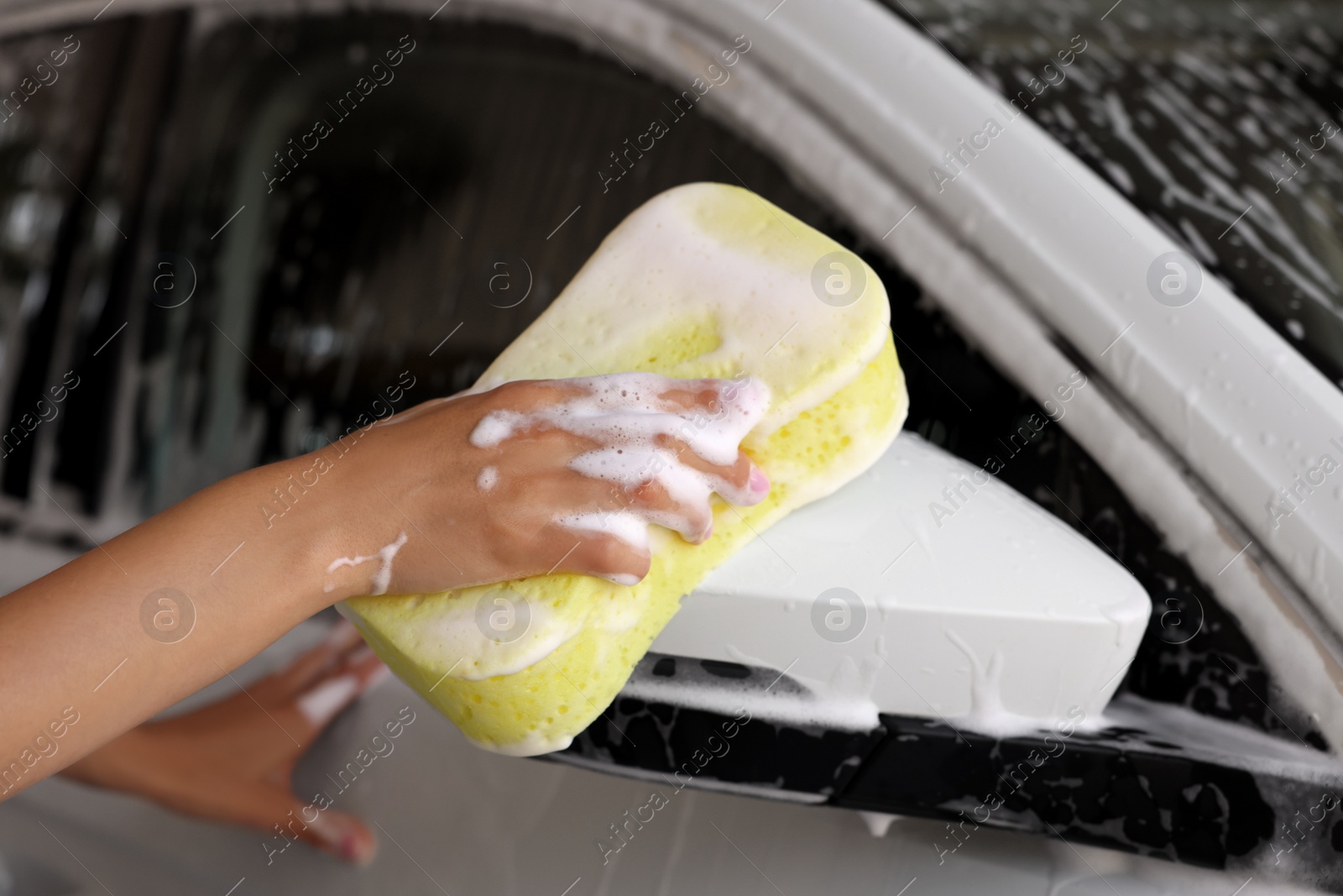 Photo of Woman washing car with sponge, closeup view