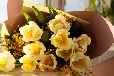 Bouquet with beautiful tulips and mimosa flowers on windowsill indoors