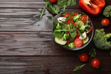 Photo of Tasty fresh vegetarian salad on dark wooden table, flat lay. Space for text