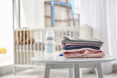 Stack of stylish child clothes on table indoors