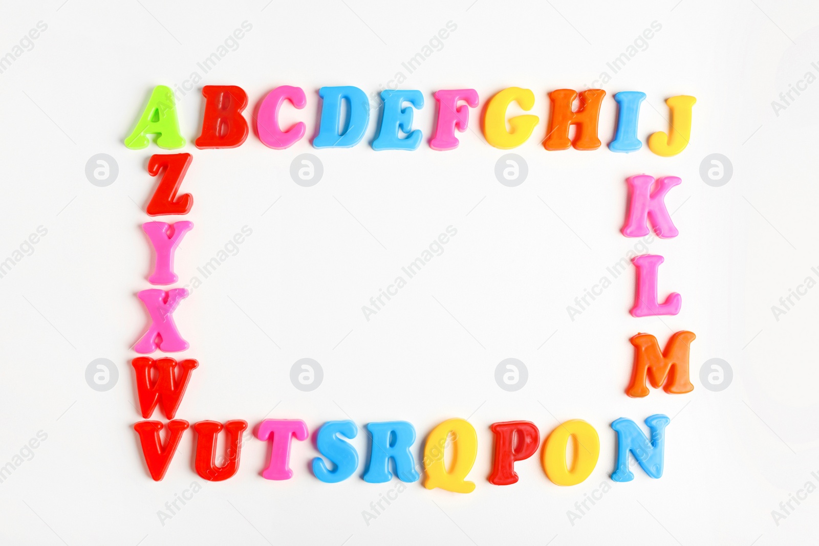 Photo of Frame of colorful magnetic letters on white background, flat lay with space for text. Alphabetic order