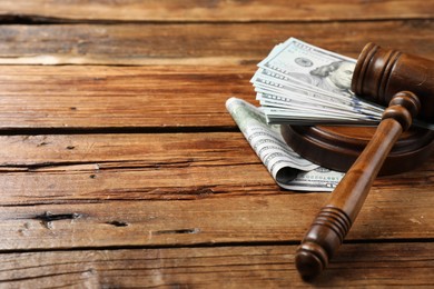 Photo of Judge's gavel and money on wooden table, closeup. Space for text