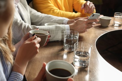 Photo of Friends with coffee spending time together in cafe, closeup