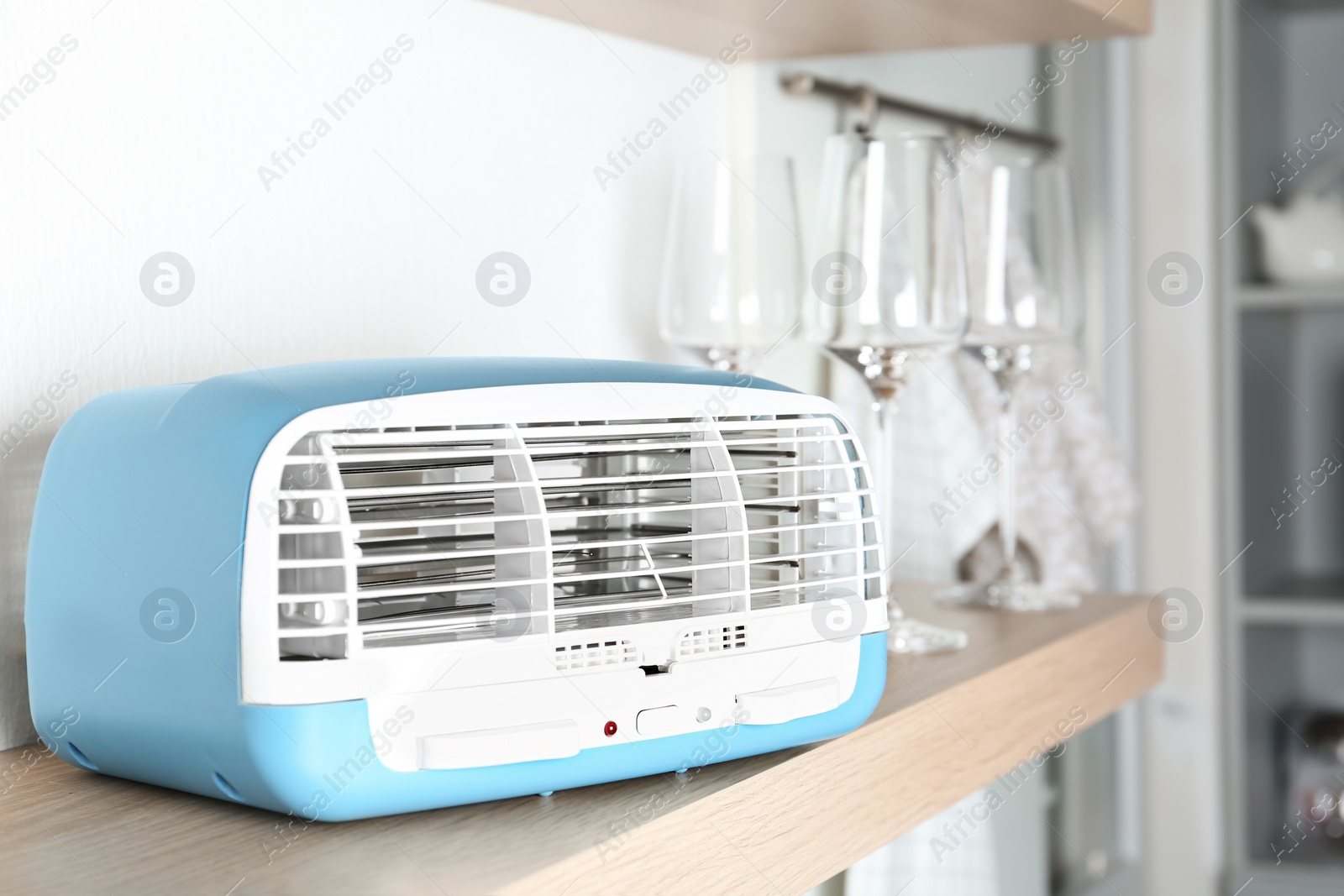 Photo of Modern air purifier on wooden shelf, closeup