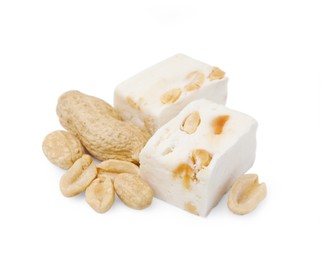 Photo of Pieces of delicious nougat and nuts on white background