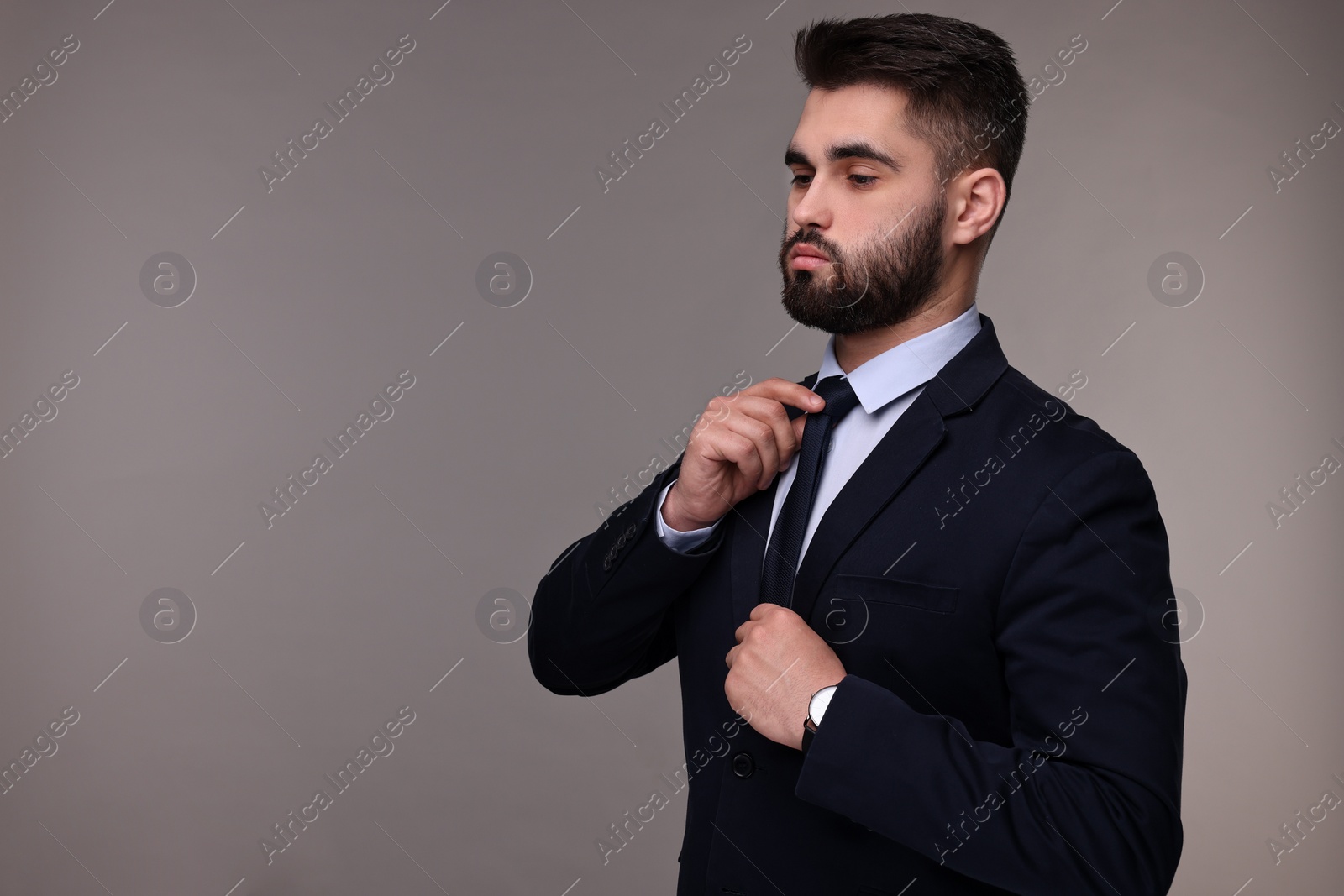 Photo of Handsome businessman in suit and necktie on grey background. Space for text