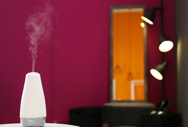 Photo of Aroma oil diffuser on table indoors. Air freshener