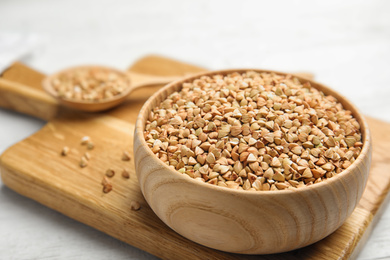 Uncooked green buckwheat grains on wooden board