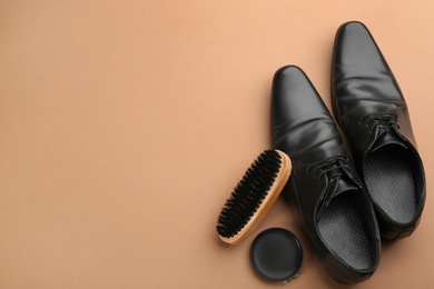 Flat lay composition with shoe care accessories and footwear on brown background. Space for text