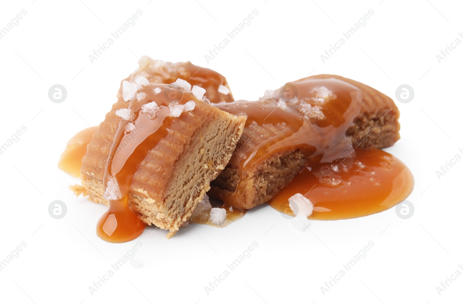 Photo of Yummy caramel candies and sea salt isolated on white