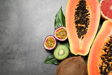 Fresh ripe papaya and other fruits on grey table, flat lay. Space for text