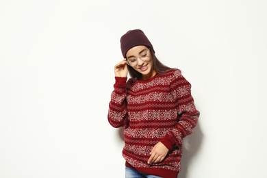 Photo of Young woman in warm sweater and hat on white background. Celebrating Christmas