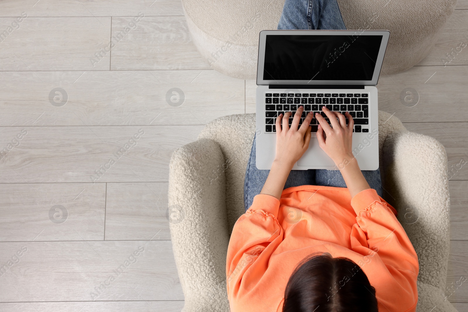 Photo of Woman working with laptop in armchair, top view. Space for text