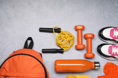 Different sports equipment on light grey table, flat lay