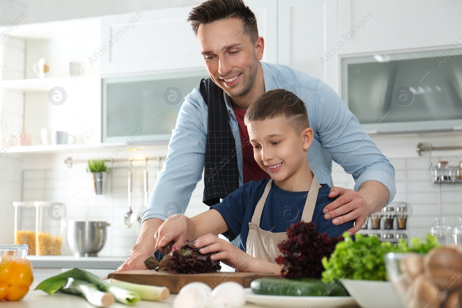 Photo of Dad and son cooking together in kitchen