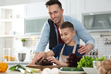 Dad and son cooking together in kitchen