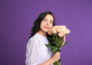 Photo of Young woman with beautiful bouquet on purple background