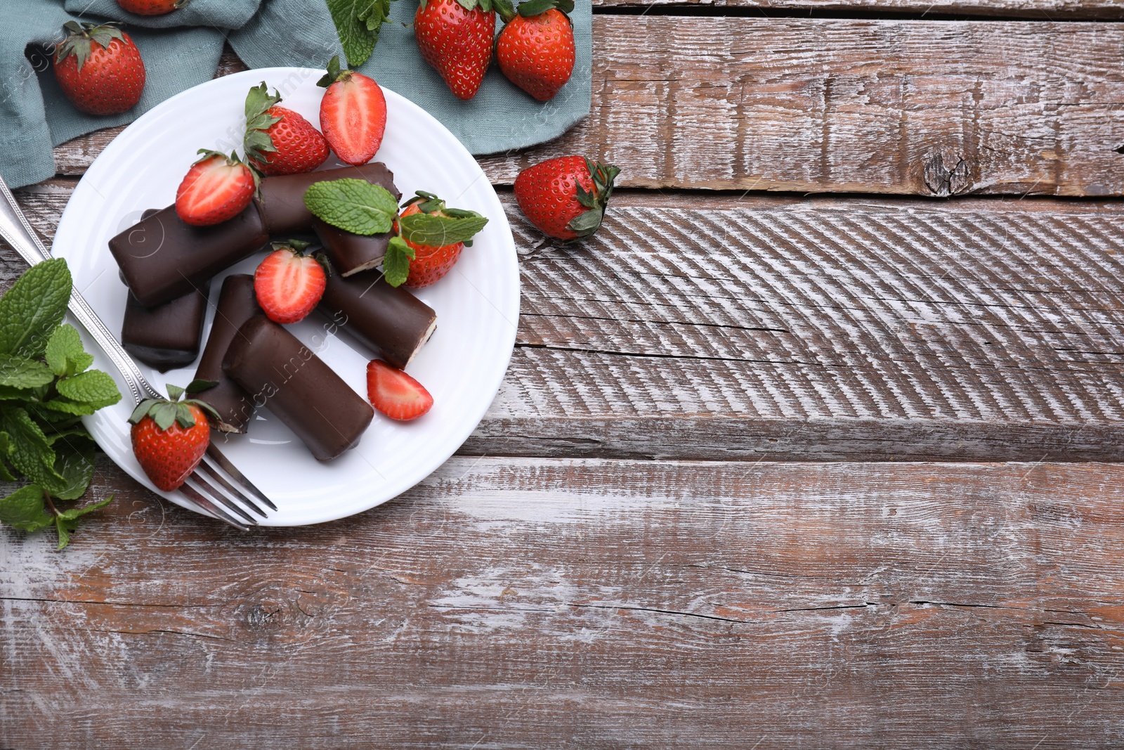 Photo of Delicious glazed curd snacks with fresh strawberries and mint on wooden table, flat lay. Space for text