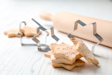 Photo of Tasty homemade Christmas cookies and cutters on table