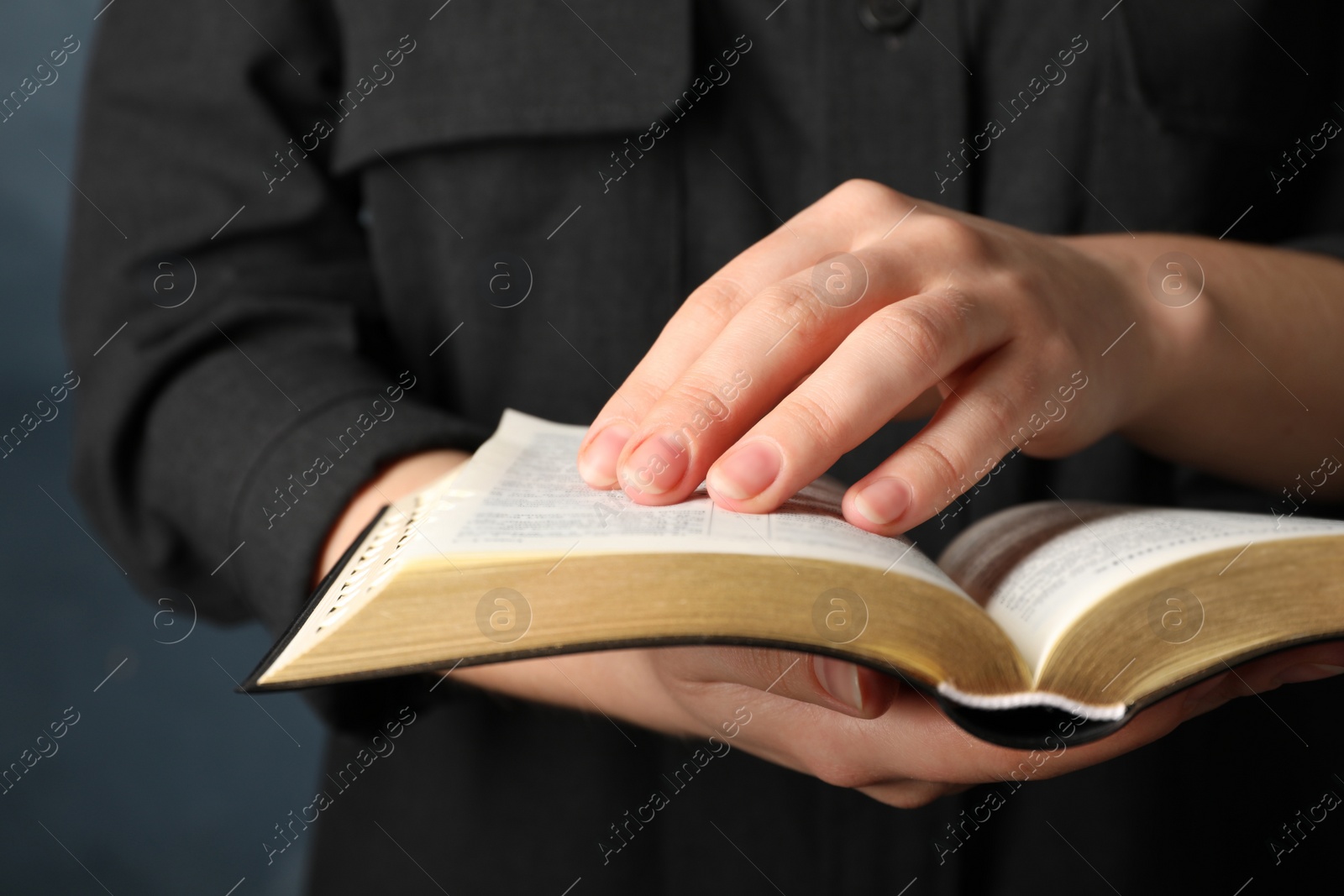 Photo of Humble woman reading Bible, closeup. Religious literature