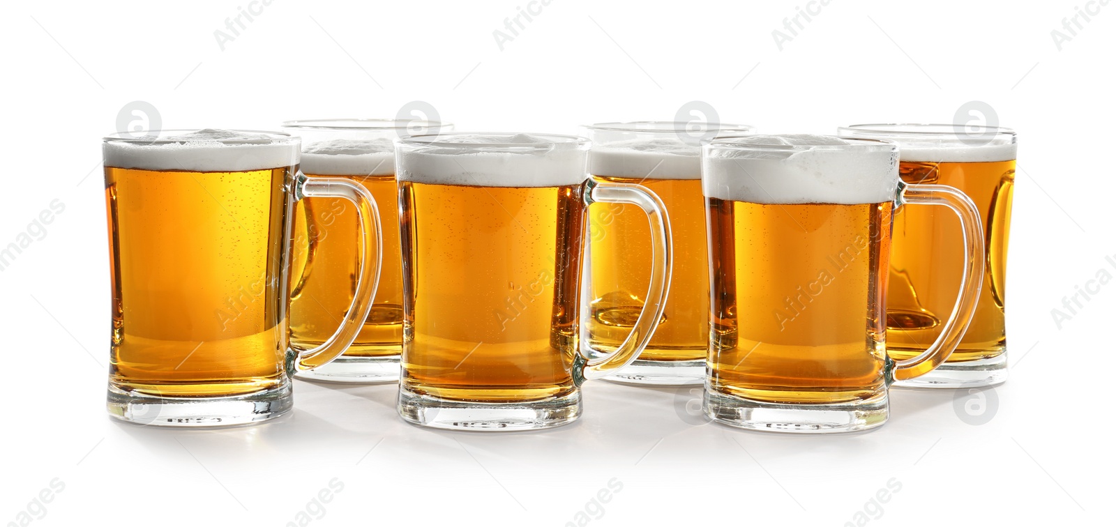 Photo of Glass mugs of beer on white background