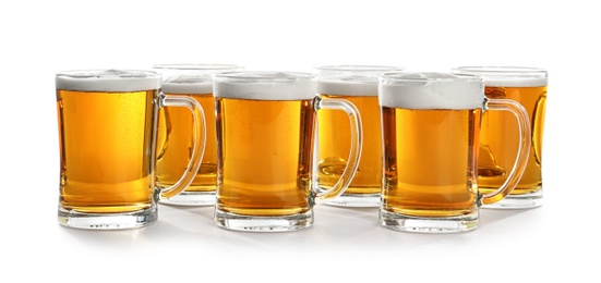 Glass mugs of beer on white background