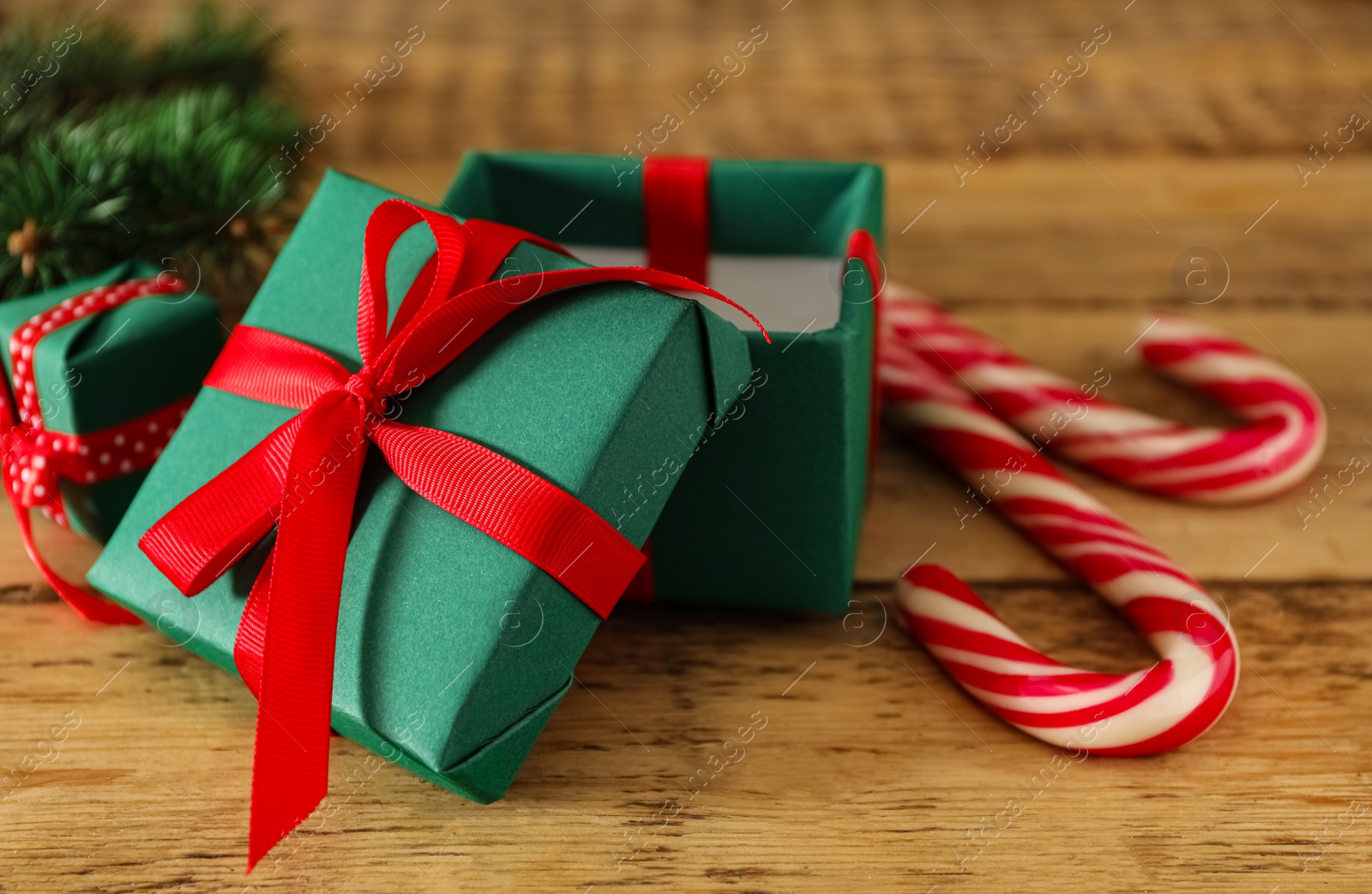 Photo of Green Christmas gift boxes with candy canes on wooden table