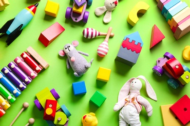 Photo of Different toys on green background, flat lay