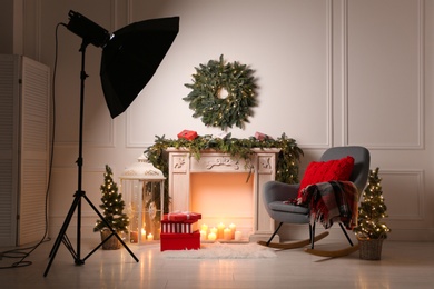 Photo of Beautiful Christmas themed photo zone with professional equipment and fireplace