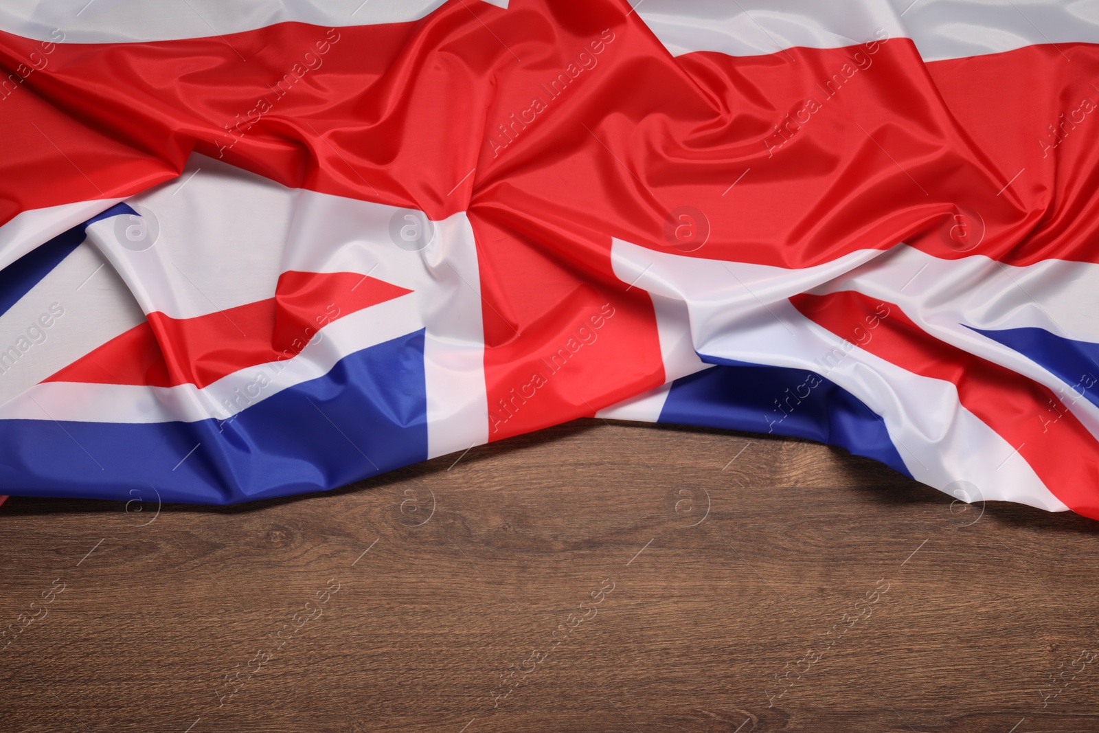 Photo of Flag of United Kingdom on wooden background, top view. Space for text