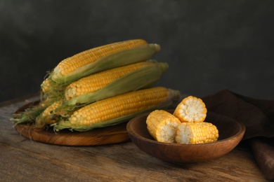 Tasty sweet corn cobs on wooden table