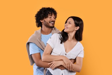 Photo of International dating. Happy couple hugging on yellow background