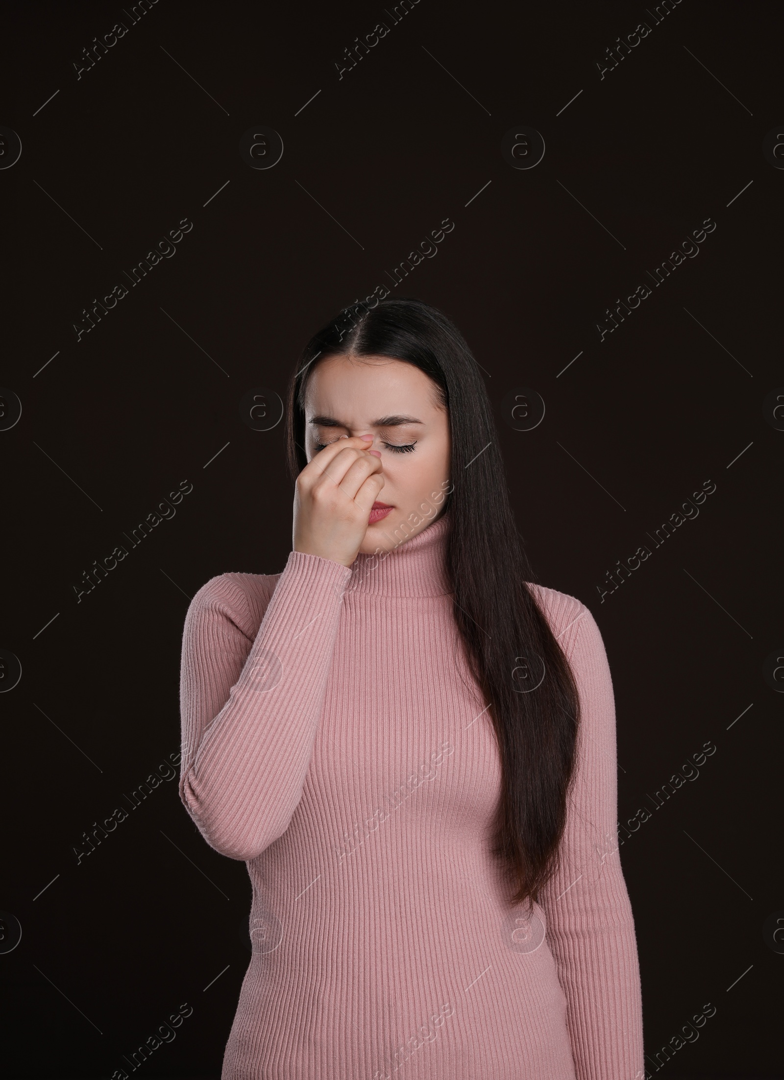 Photo of Young woman suffering from cold on dark background