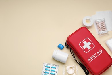 Photo of Flat lay composition with first aid kit on beige background. Space for text