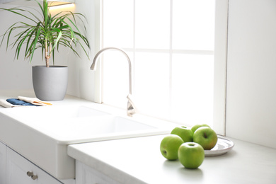 Photo of Beautiful Dracaena plant near sink in modern kitchen