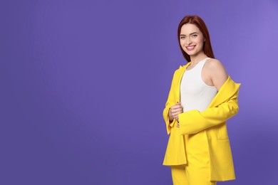 Happy woman with red dyed hair on purple background, space for text