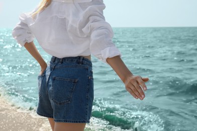 Young woman near sea on sunny day in summer, closeup