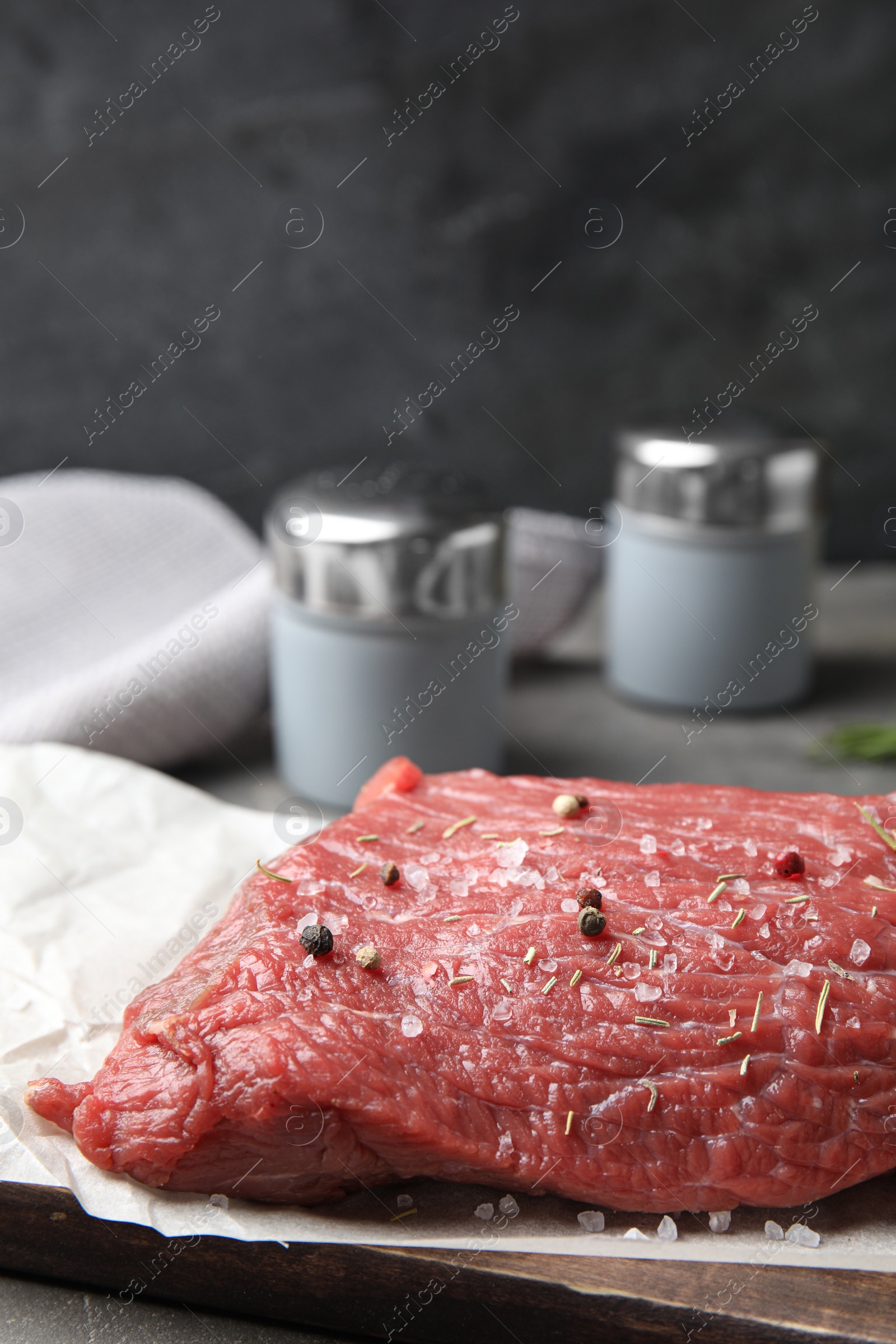 Photo of Fresh raw beef cut with spices on table, closeup