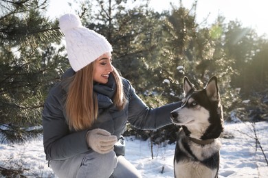 Young woman with dog in forest on winter day