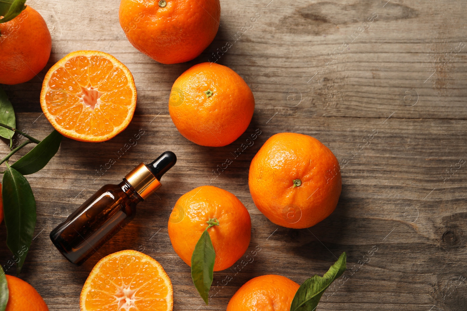 Photo of Flat lay composition with tangerine essential oil on wooden table, space for text