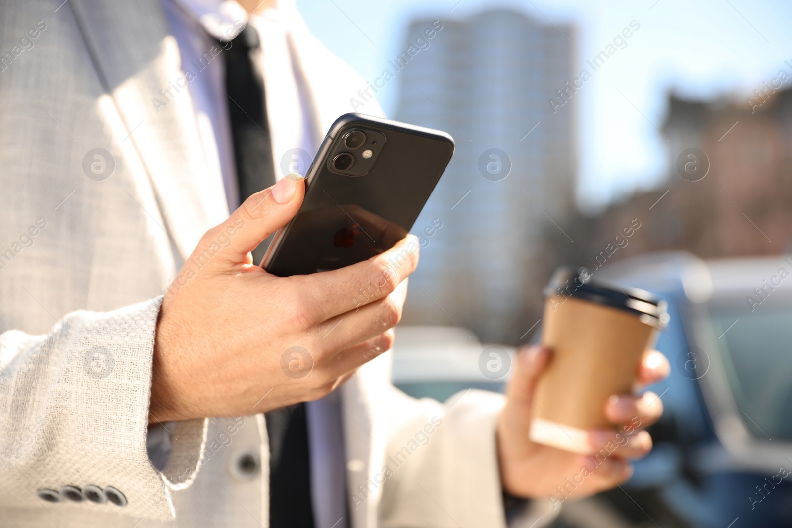 Photo of MYKOLAIV, UKRAINE - MARCH 16, 2020: Man holding iPhone 11 Black outdoors, closeup