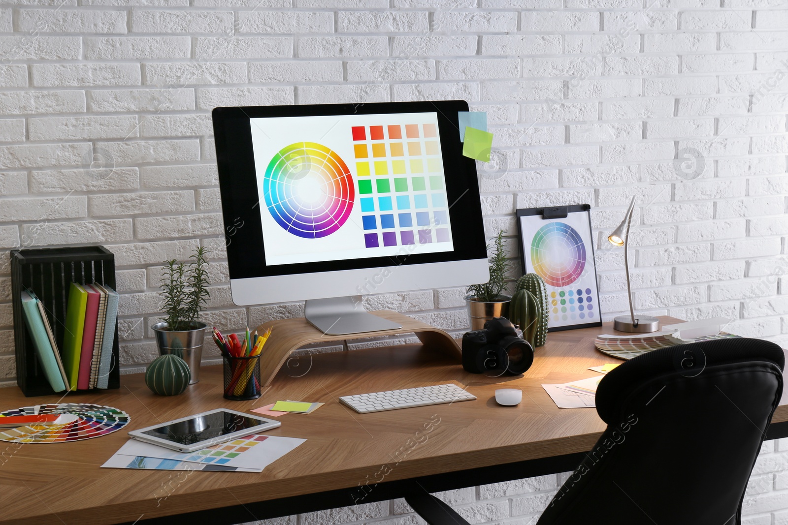 Photo of Modern computer and office supplies on wooden table. Designer's workplace