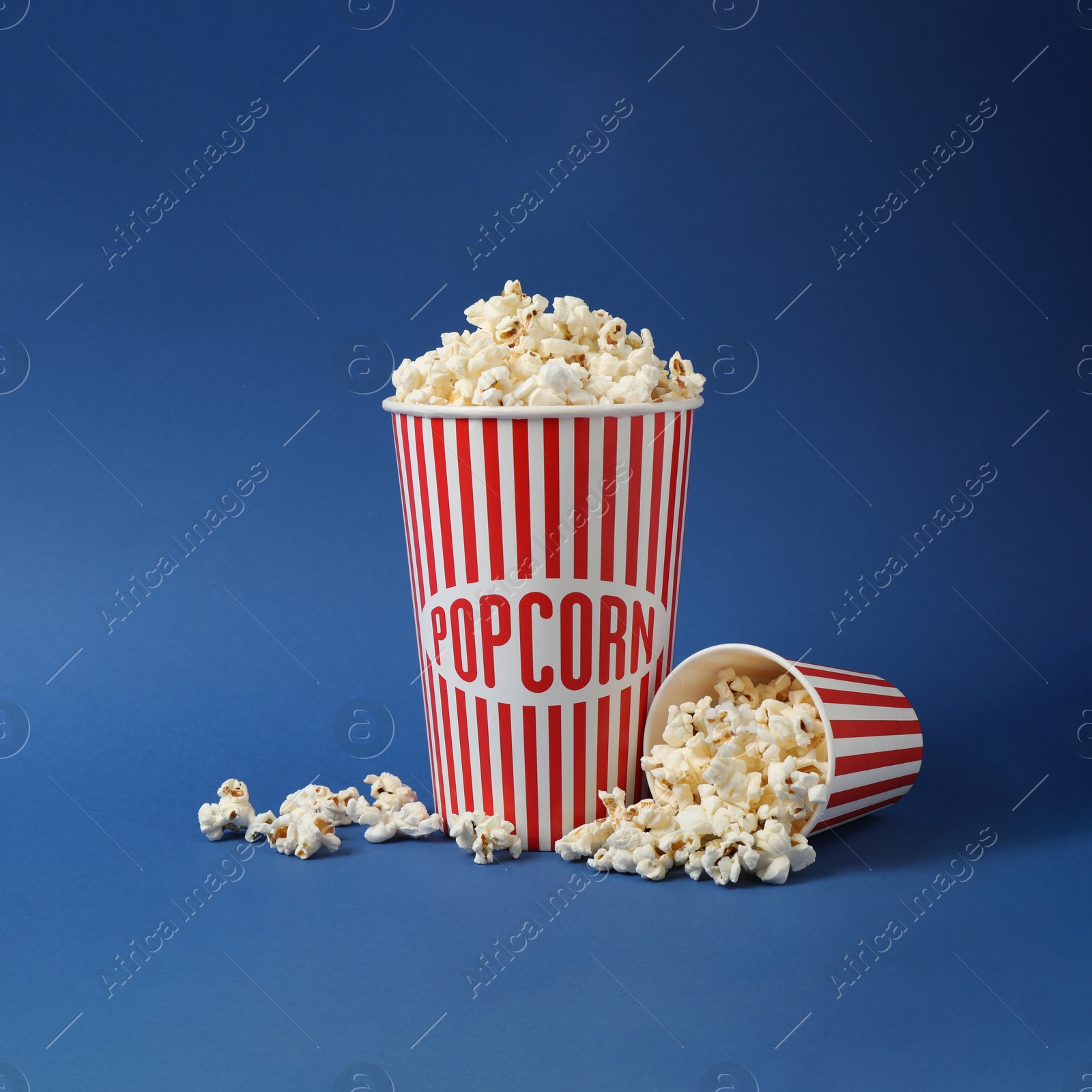 Photo of Delicious popcorn on blue background. Space for text