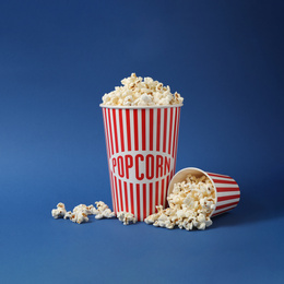 Photo of Delicious popcorn on blue background. Space for text