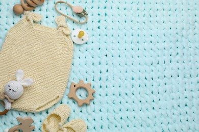 Photo of Different baby stuff on light blue knitted fabric, flat lay. Space for text